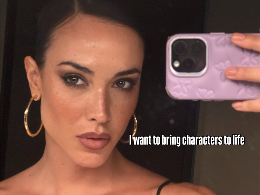 Close-up selfie of a woman with gold hoop earrings, holding a lavender phone with a floral case; caption reads “I want to bring characters to life.”
