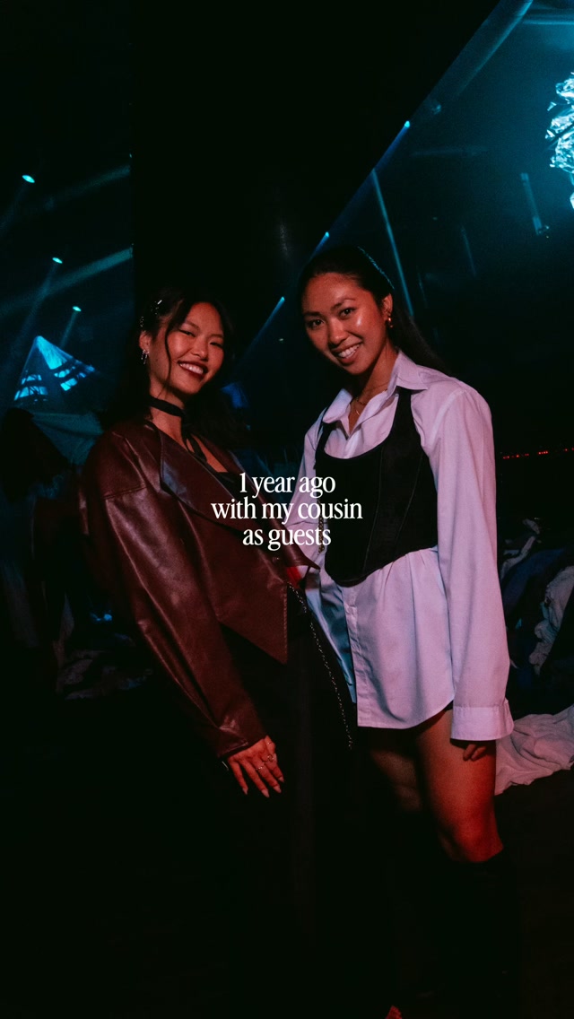 Two women smiling at a nightclub with blue stage lights, an overlaid caption: ‘1 year ago with my cousin as guests’.
